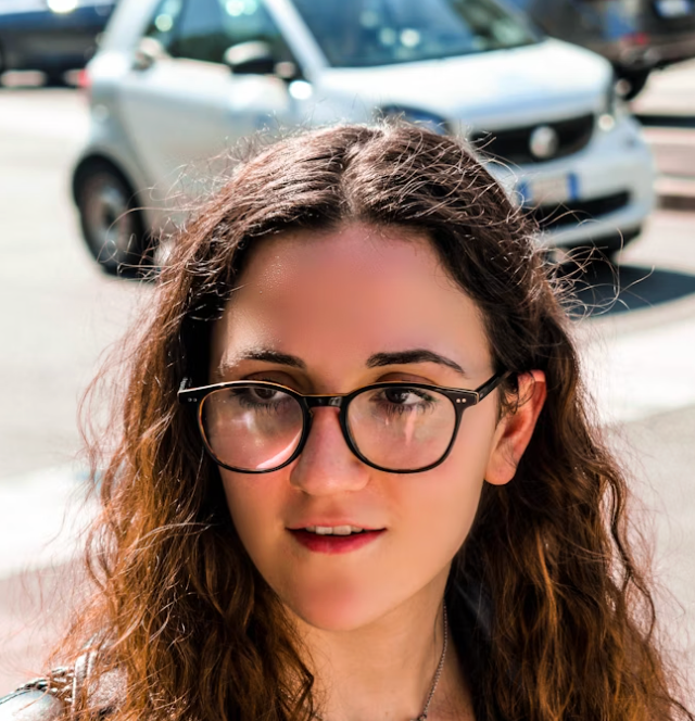 Woman with glasses smiling outside